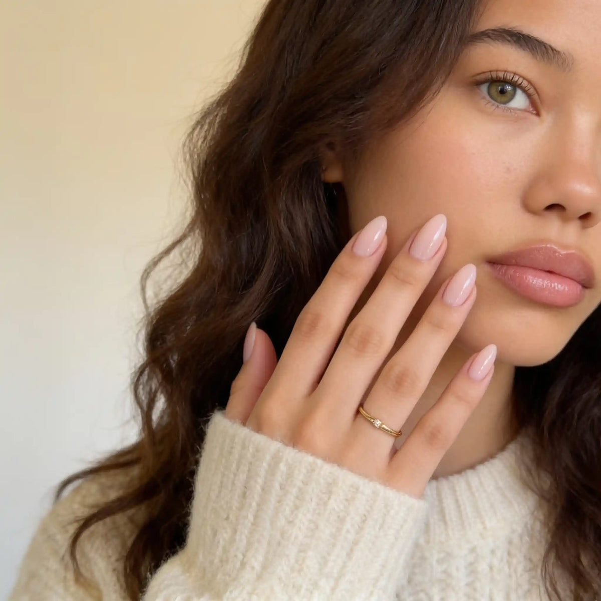 Porträt eines Models, das die kurzen, mandelförmigen, hellrosa „Blush Silk“-Nägel von Aimee STHLM präsentiert