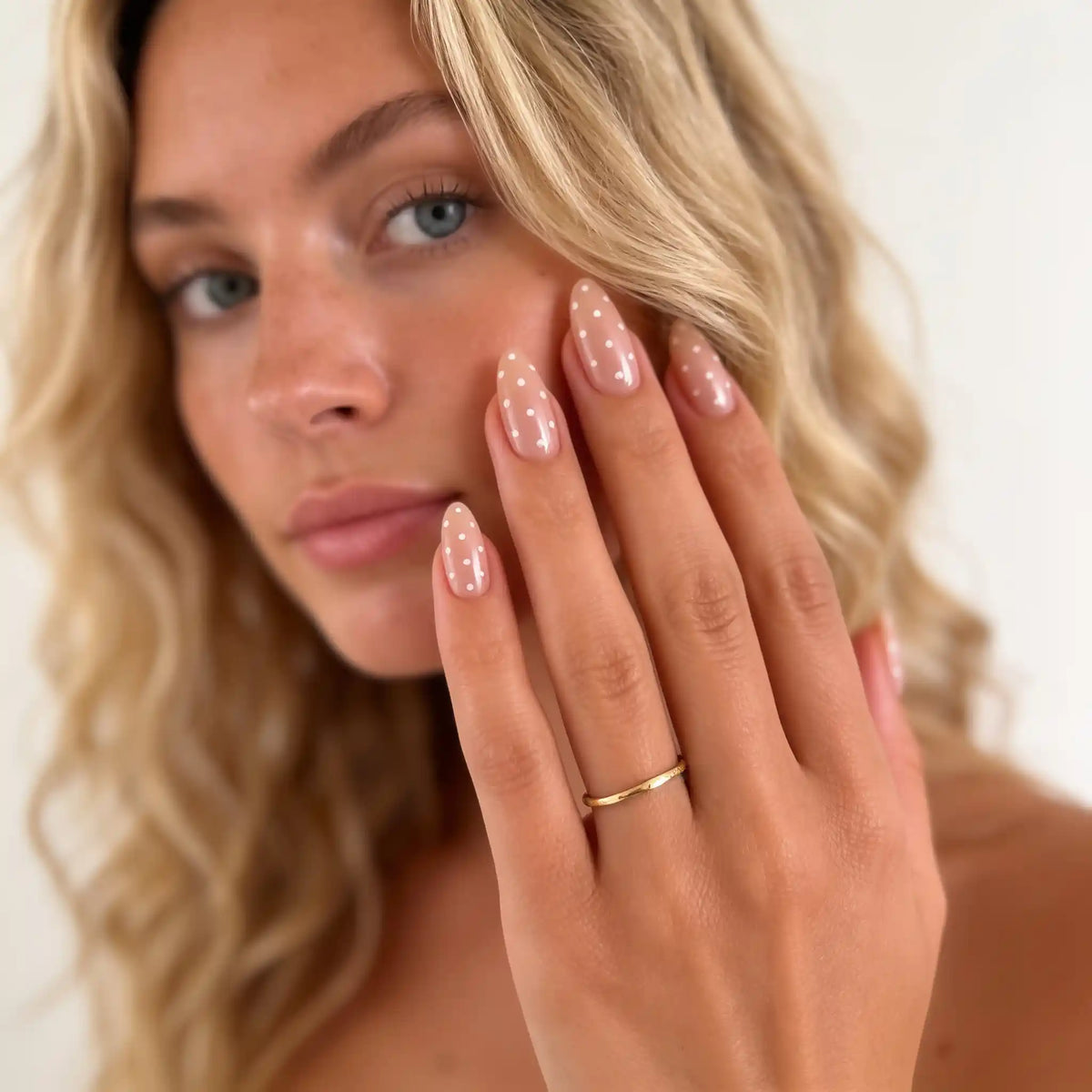 Blondes Model präsentiert die kurzen, mandelförmigen, gemusterten Nägel „Dew Drops“ von Aimee STHLM