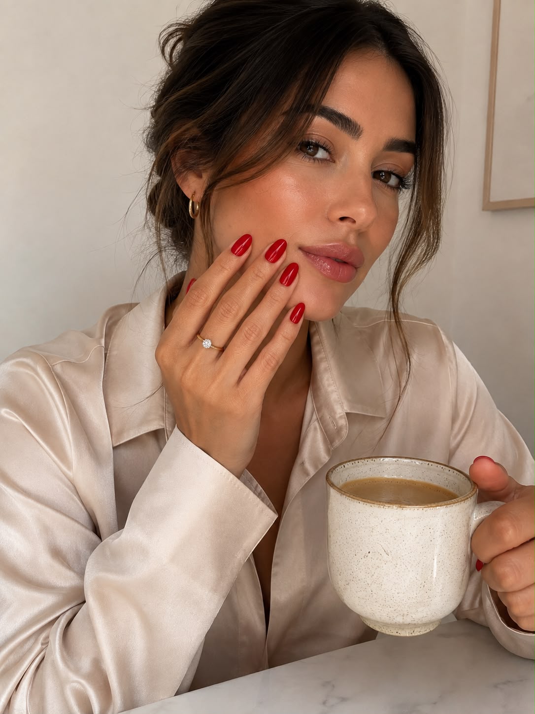 Model med kaffekop, der viser STHLM Rouges elegante røde kunstige negle (press-on-negle) fra Aimee STHLM