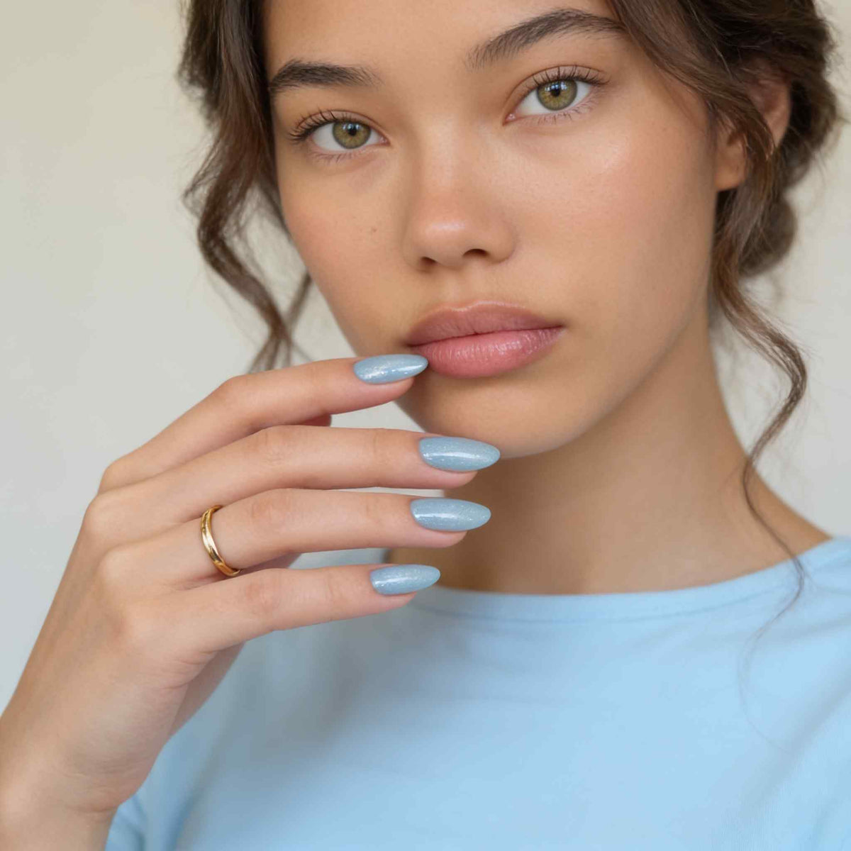 Model in blauem Oberteil, das hellblaue „Winter Sky“-Cat-Eye-Press-On-Nägel von Aimee STHLM trägt