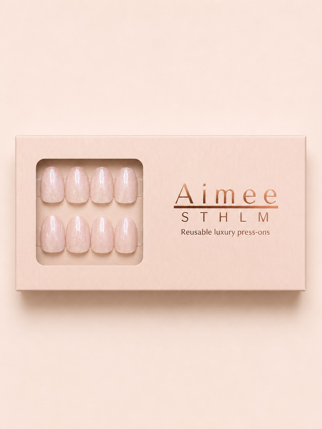 Champagne Cheers-Schachtel – Wiederverwendbare, schimmernde Cat-Eye-Kunstnägel in der Form „Extra Short Oval“, verpackt in einer exklusiven Schachtel von Aimee STHLM