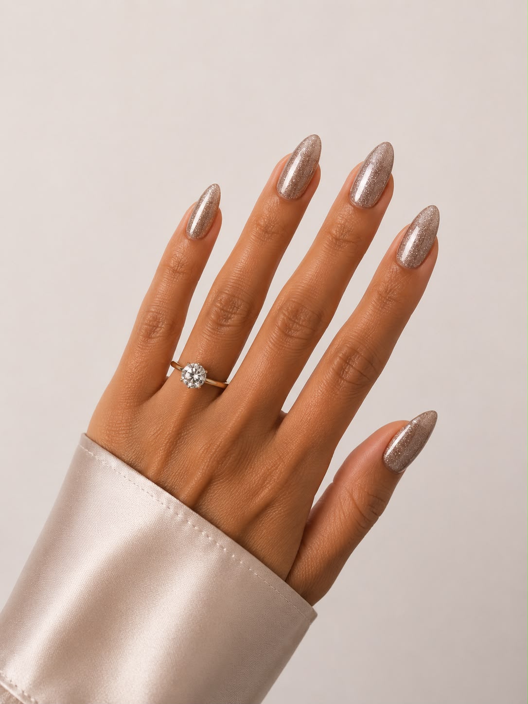 Champagne Frost – Kurze, mandelförmige (Short Almond) glitzernde Cat-Eye-Klebe-Nägel in Champagnerfarbe, von Hand aufgetragen von Aimee STHLM