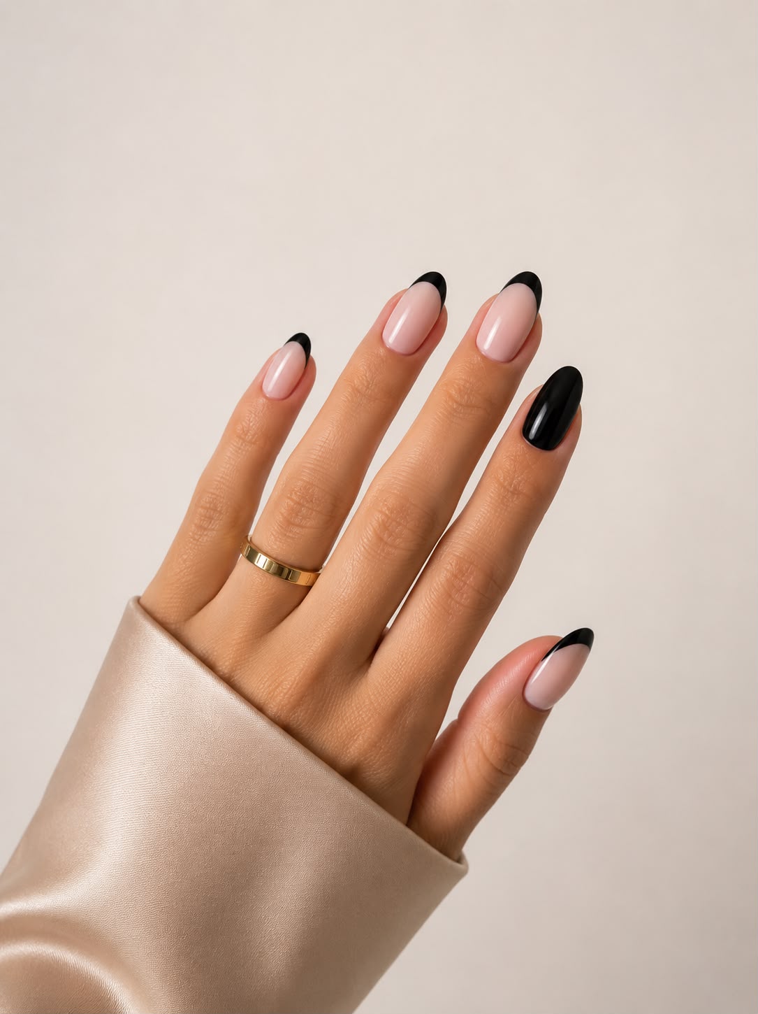 Dark Ballet – Kurze ovale (Short Oval) Klebe-Nägel mit schwarzer French-Maniküre, auf der Hand von Aimee STHLM getragen