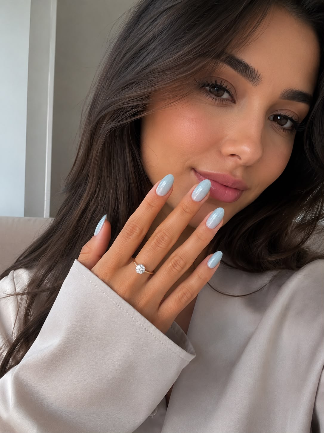Model mit kurzen, mandelförmigen, eisblauen „Frost Bite“-Cat-Eye-Klebe-Nägeln von Aimee STHLM