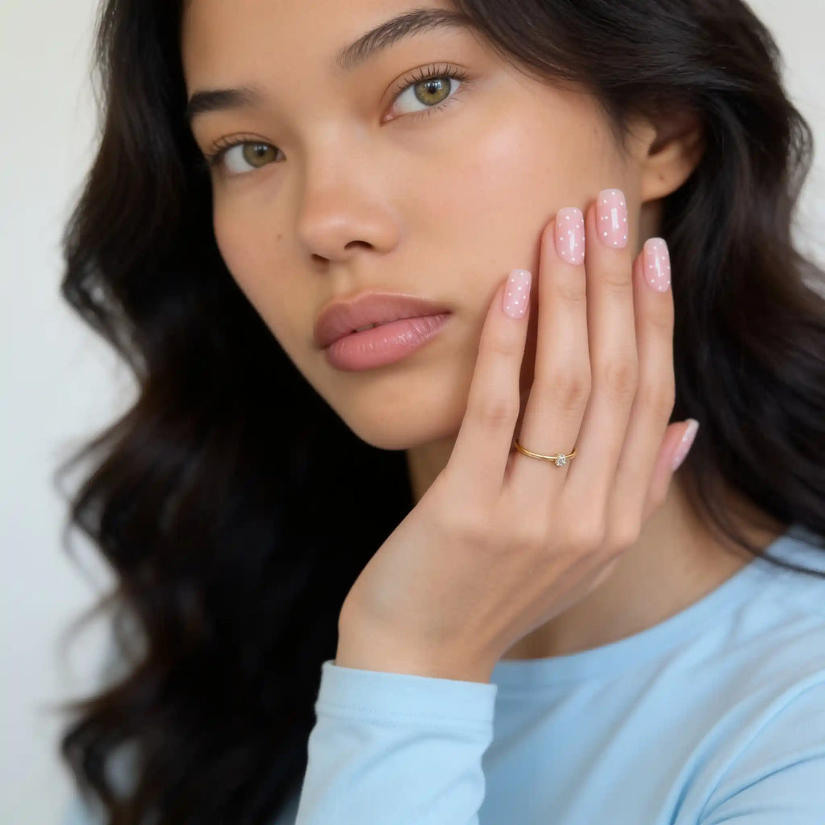 Model mit kurzen, eckigen, rosa gepunkteten Press-on-Nägeln in der Farbe „Polka Pink“ von Aimee STHLM