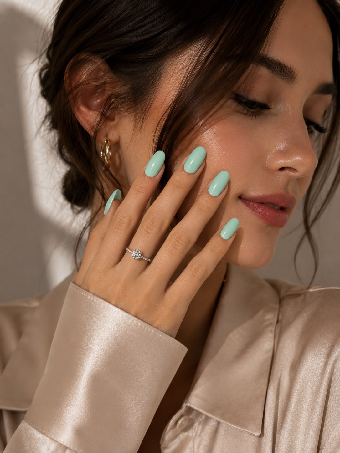 Model mit kurzen, ovalen, salbeigrünen „Soft Sage“-Press-on-Nägeln von Aimee STHLM