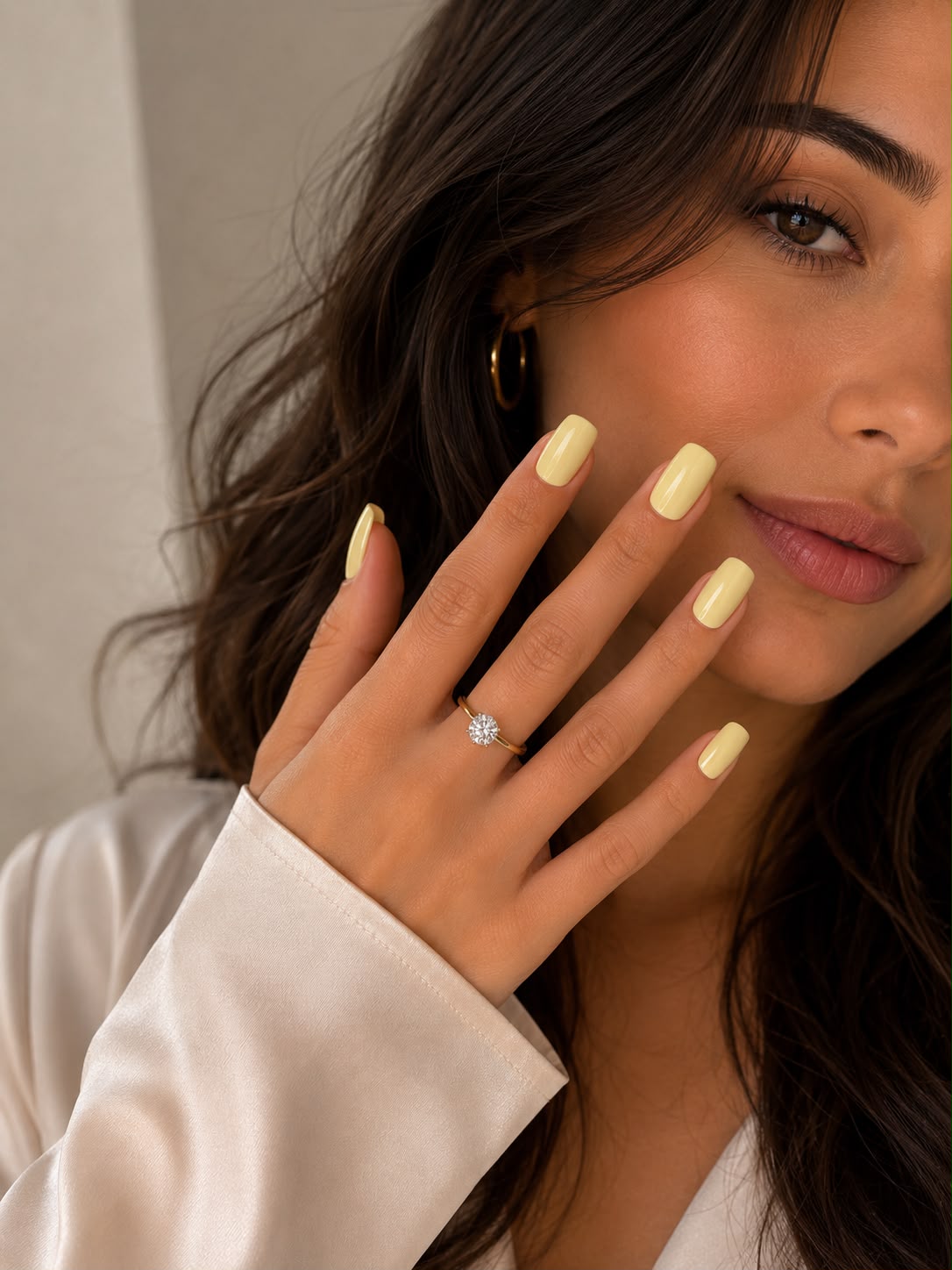 Model mit kurzen, eckigen, pastellgelben „Vanilla Cream“-Press-on-Nägeln von Aimee STHLM